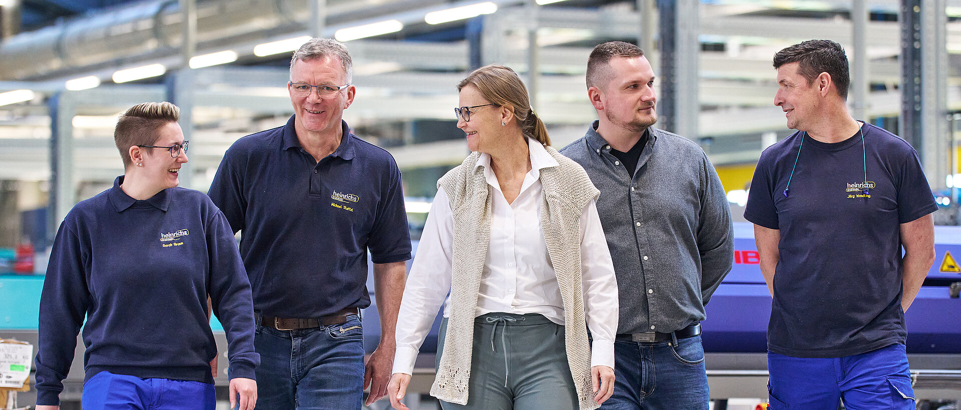 Gruppenbild mehrerer Mitarbeiter von heinrichs drehteile in der Produktionshalle