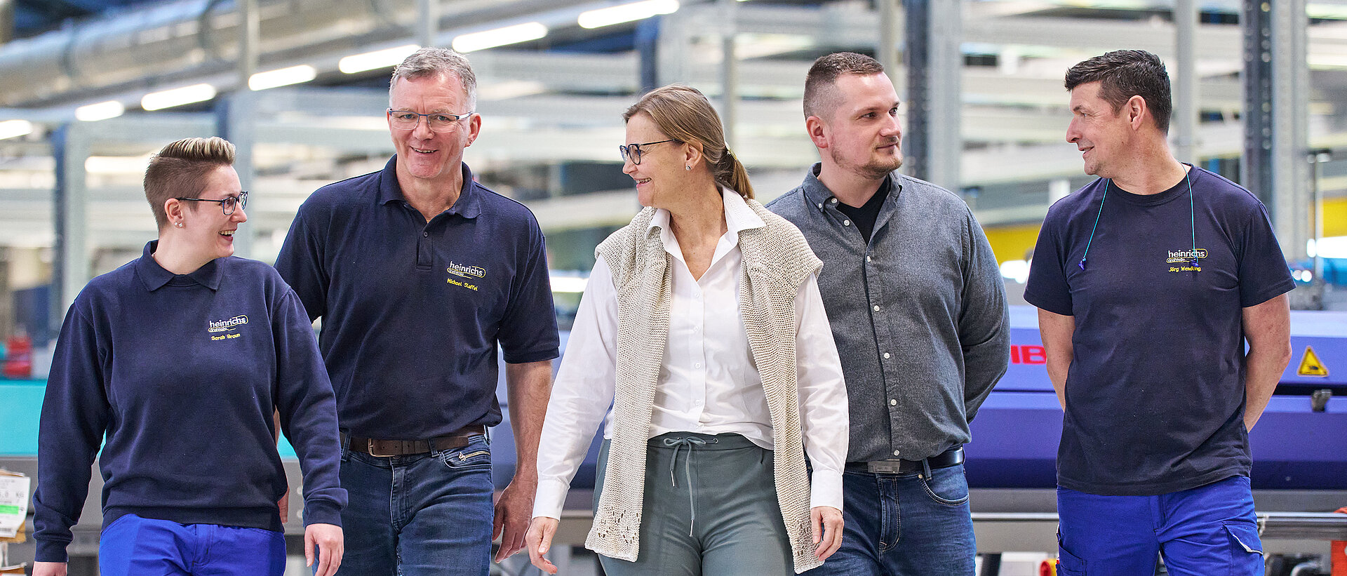 Gruppenbild mehrerer Mitarbeiter von heinrichs drehteile in der Produktionshalle