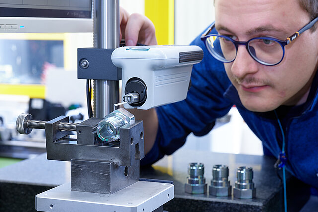 Mitarbeiter überprüft Drehteil
