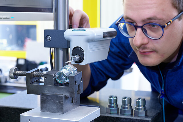 Mitarbeiter überprüft Drehteil