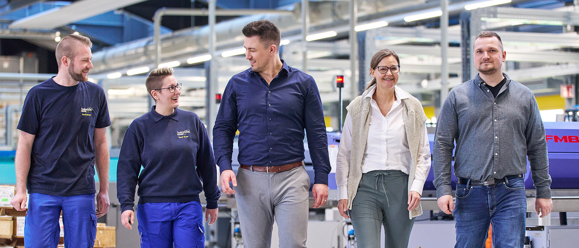 Gemischtes Team in der Werkhalle von heinrichs