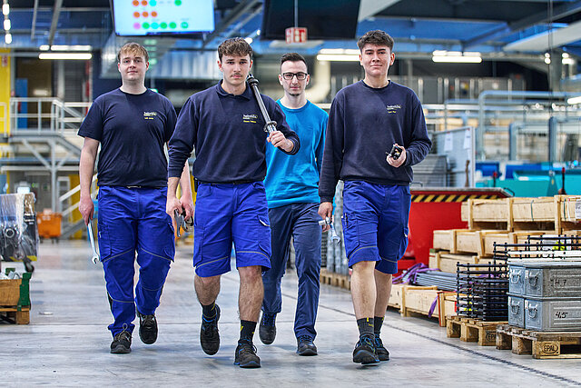 Drei Azubis gehen durch die Produktion